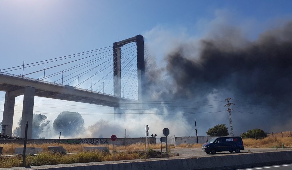 Una enorme columna de humo cubre el puente del Centenario en Sevilla