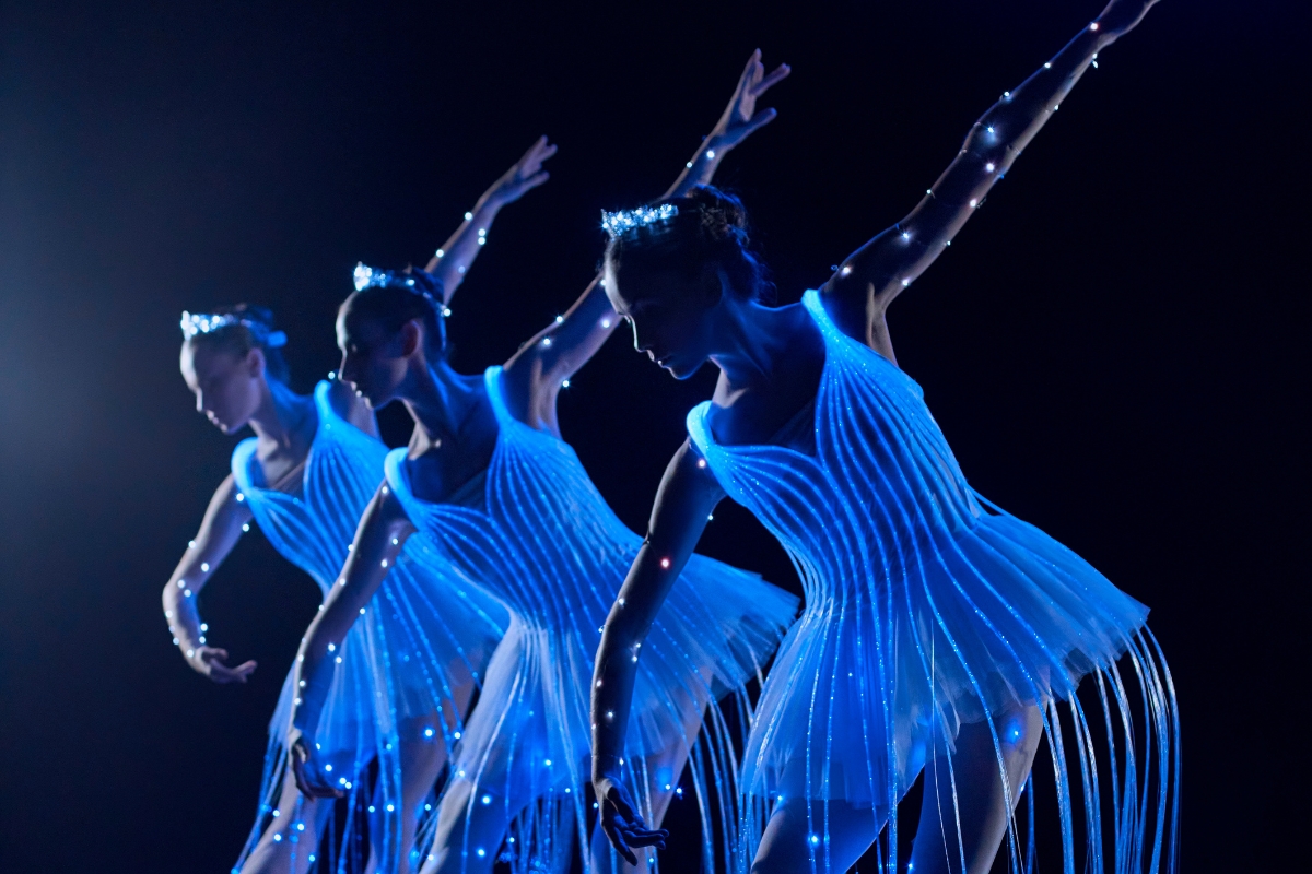 Bailarinas de ballet ataviadas de trajes LED sobre el escenario de We call it Ballet Sevilla